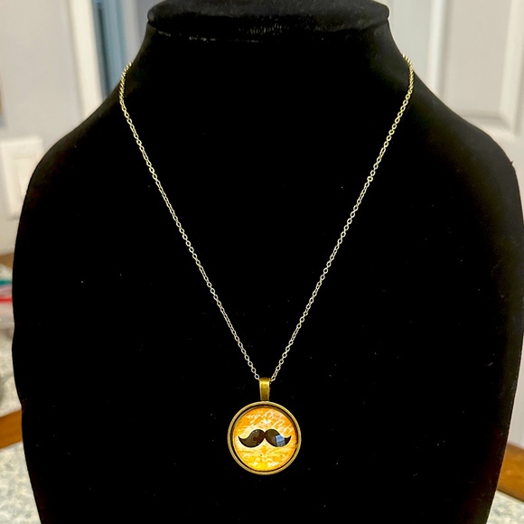 Antiqued Gold Mustache Pendant Necklace. Orange cursive writing background - Picture 1 of 4